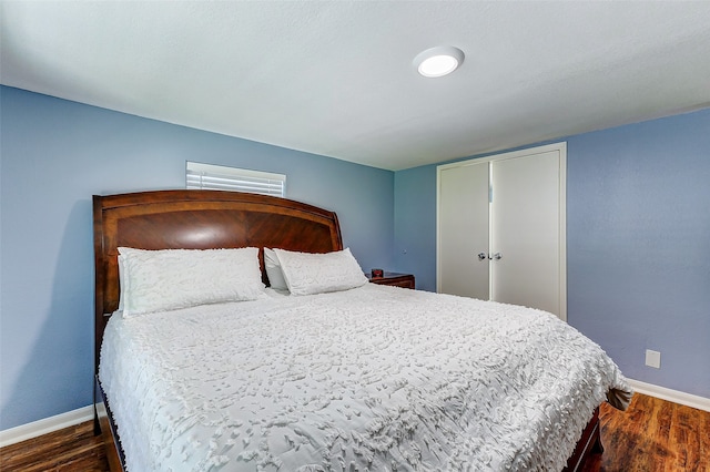 bedroom with a closet and dark wood-type flooring