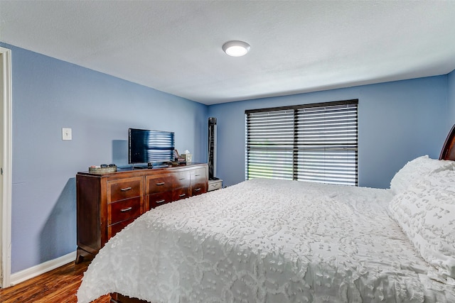 bedroom with a textured ceiling and dark hardwood / wood-style floors