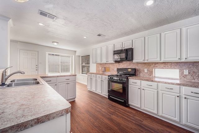 kitchen with black appliances, white cabinets, sink, dark hardwood / wood-style floors, and decorative backsplash