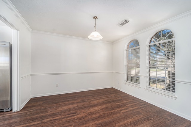 empty room with a textured ceiling, dark hardwood / wood-style flooring, and crown molding