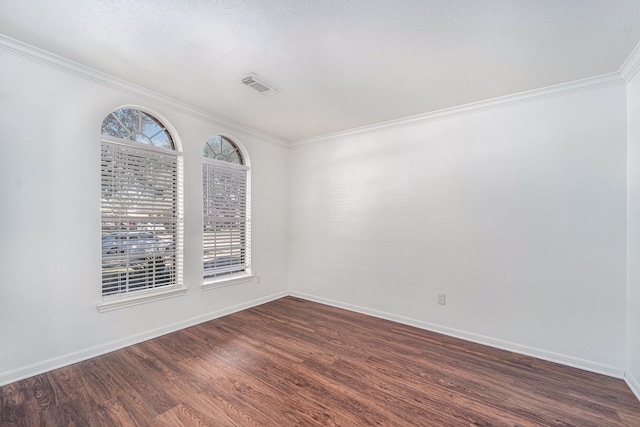 empty room featuring dark hardwood / wood-style floors, a healthy amount of sunlight, and ornamental molding