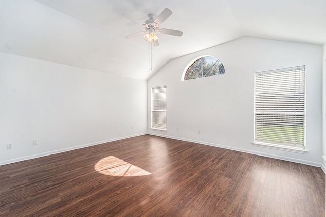 empty room with ceiling fan, plenty of natural light, dark wood-type flooring, and vaulted ceiling