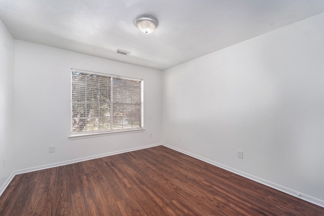 spare room featuring wood-type flooring and a textured ceiling