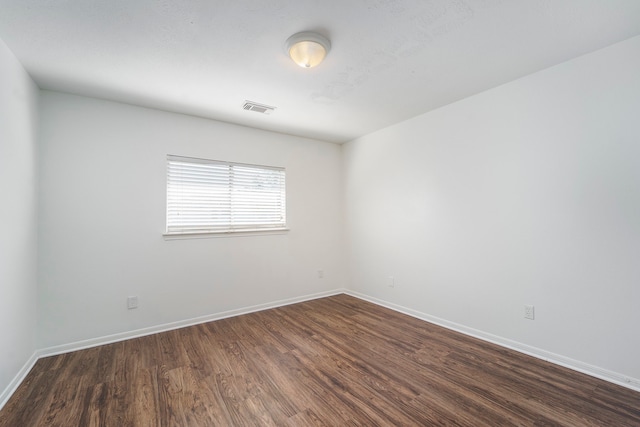 unfurnished room featuring dark wood-type flooring