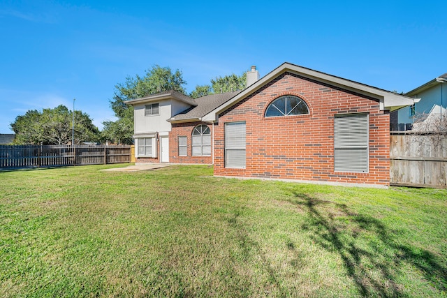 rear view of house featuring a patio and a lawn