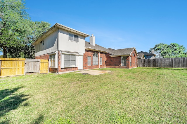 rear view of property featuring a yard and a patio