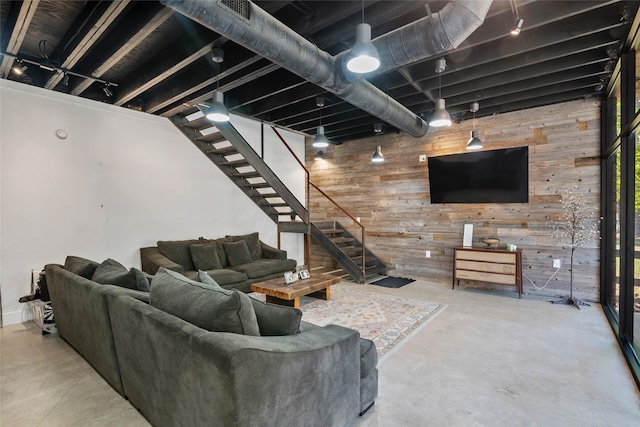 living room featuring wood walls and concrete flooring