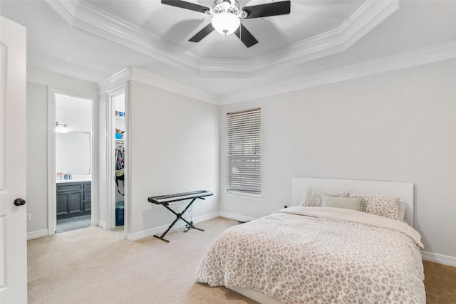 bedroom featuring ceiling fan, a raised ceiling, carpet flooring, crown molding, and ensuite bathroom