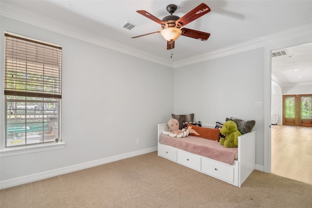 carpeted bedroom with ornamental molding and ceiling fan