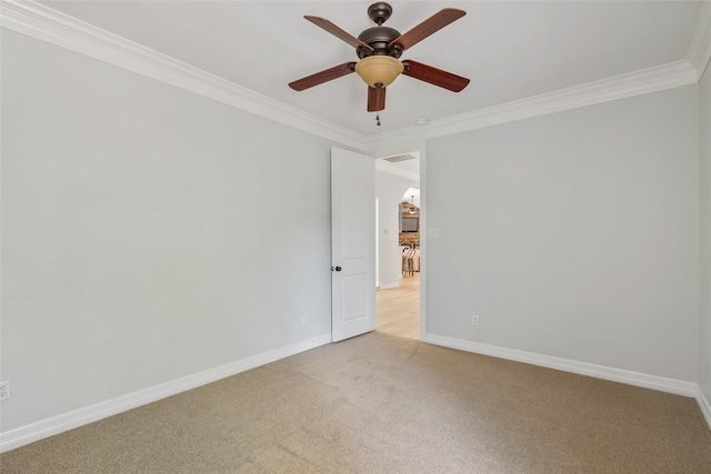 unfurnished room featuring ceiling fan, light colored carpet, and ornamental molding