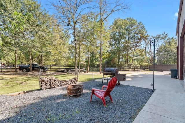 view of yard featuring an outdoor fire pit and a patio area