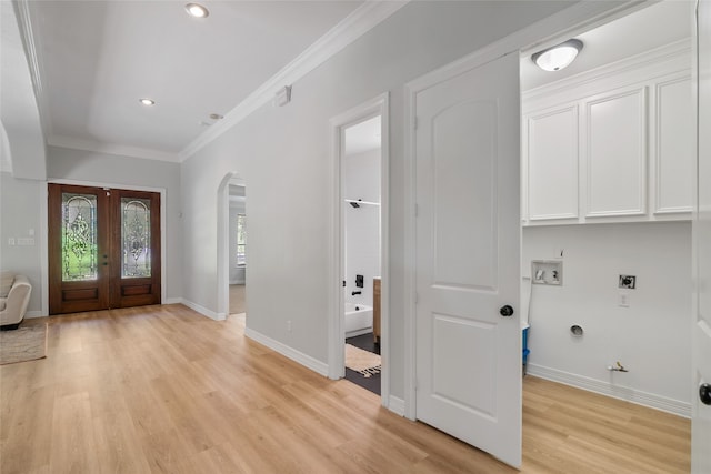 interior space with light wood-type flooring, french doors, and crown molding