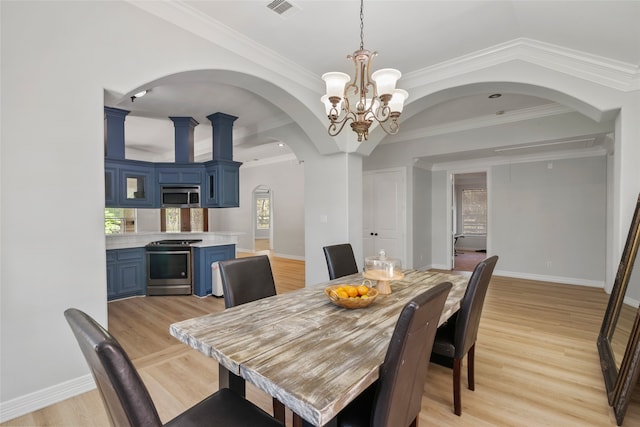 dining room featuring ornamental molding, light wood-type flooring, and a chandelier