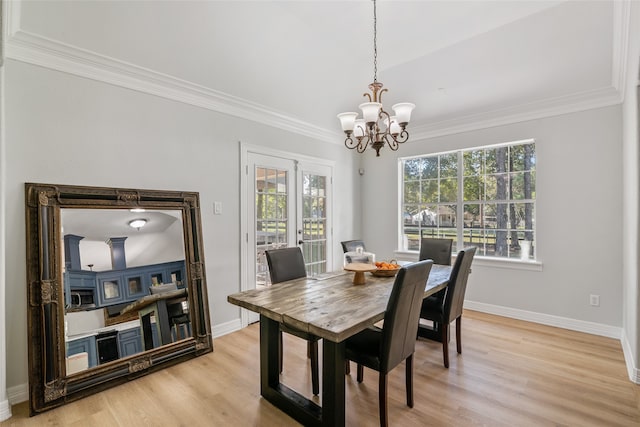 dining area featuring an inviting chandelier, crown molding, and light hardwood / wood-style floors