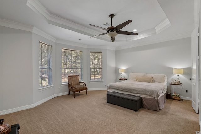 carpeted bedroom with a tray ceiling, ornamental molding, and ceiling fan