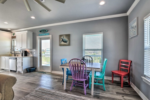 dining room with crown molding, sink, dark wood-type flooring, and ceiling fan