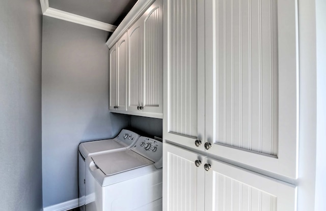 washroom with ornamental molding, washer and clothes dryer, and cabinets