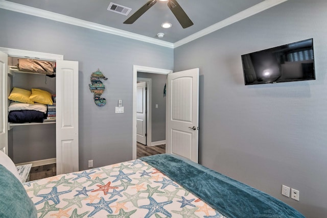 bedroom with crown molding, dark hardwood / wood-style floors, and ceiling fan