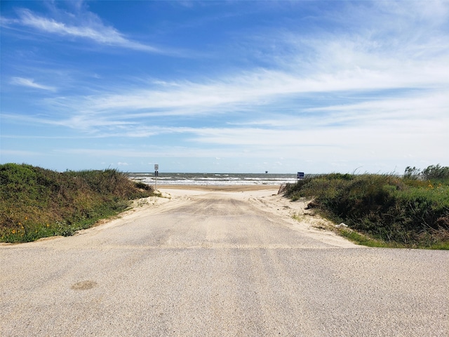 view of street featuring a water view and a beach view