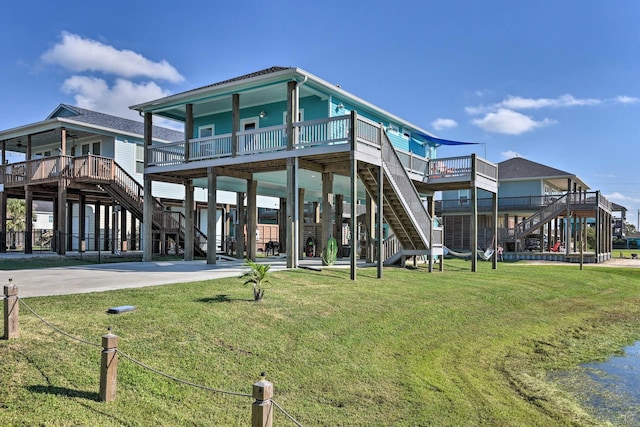 rear view of house with a wooden deck and a lawn