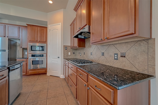 kitchen featuring tasteful backsplash, light tile patterned floors, dark stone counters, and appliances with stainless steel finishes