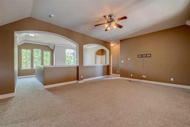 empty room with ceiling fan, light colored carpet, and lofted ceiling