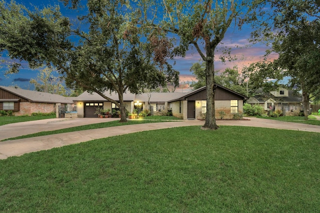 73 Surrey Oak Ct, Alvin, TX 77511 - mid-century home with concrete driveway, brick siding, a lawn, and an attached garage