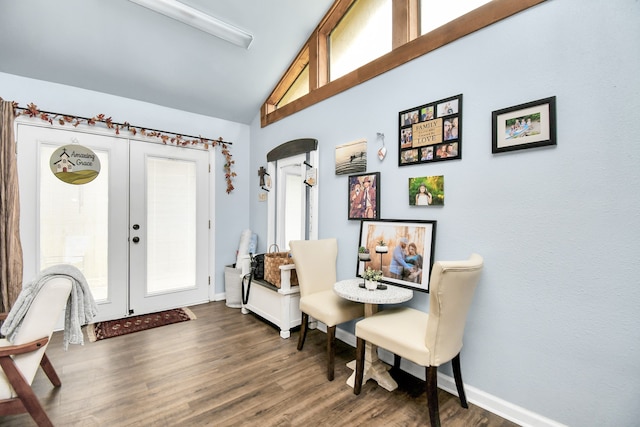 foyer with dark wood-type flooring, vaulted ceiling, and french doors