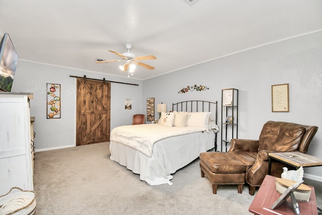 bedroom featuring ceiling fan, light colored carpet, and a barn door