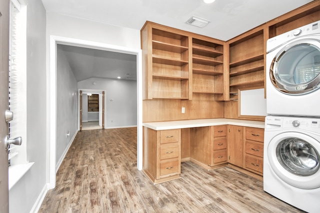 laundry area featuring light hardwood / wood-style floors and stacked washer / drying machine