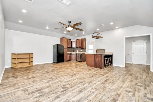 kitchen featuring ceiling fan, black fridge, dishwasher, and light wood-type flooring