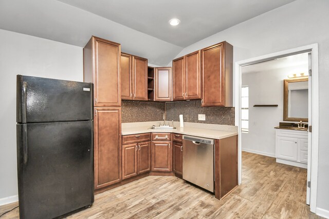 kitchen featuring decorative backsplash, light hardwood / wood-style flooring, black fridge, dishwasher, and lofted ceiling