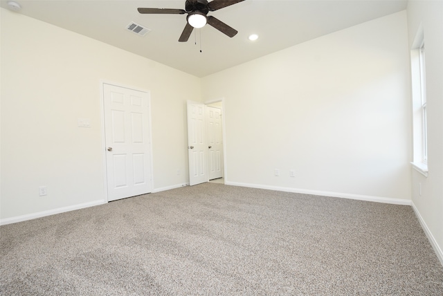 unfurnished room with ceiling fan and carpet