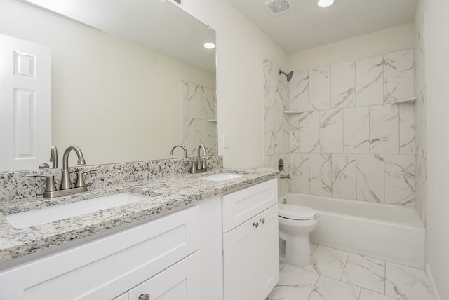 full bathroom featuring tiled shower / bath, vanity, and toilet