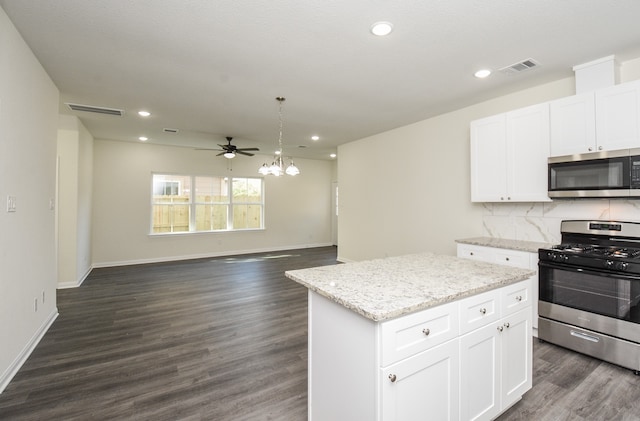 kitchen featuring white cabinets, stainless steel appliances, dark wood-type flooring, and a kitchen island