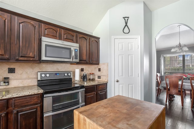 kitchen featuring dark brown cabinets, a chandelier, appliances with stainless steel finishes, dark hardwood / wood-style floors, and vaulted ceiling