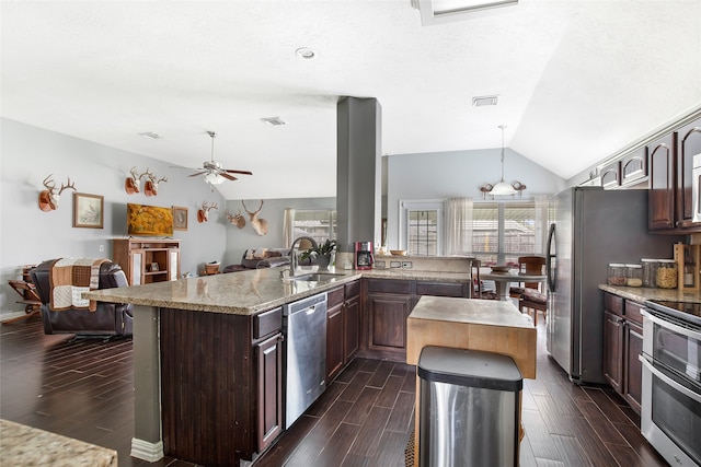 kitchen with stainless steel appliances, dark wood-type flooring, sink, kitchen peninsula, and vaulted ceiling