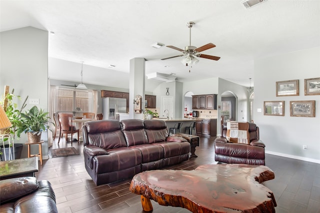 living room with dark wood-type flooring, lofted ceiling, sink, and ceiling fan