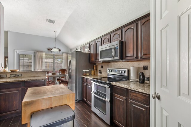 kitchen featuring stainless steel appliances, dark brown cabinetry, and lofted ceiling