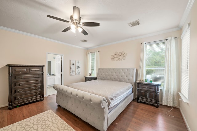 bedroom featuring ornamental molding, ensuite bath, dark wood-type flooring, and ceiling fan