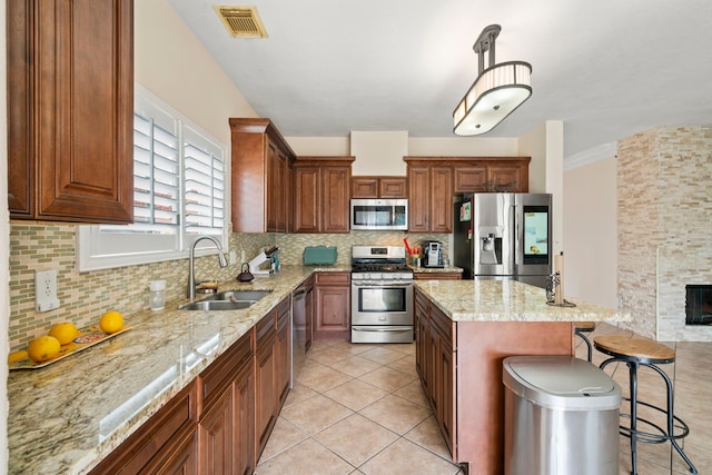 kitchen with tasteful backsplash, sink, a center island, stainless steel appliances, and a breakfast bar