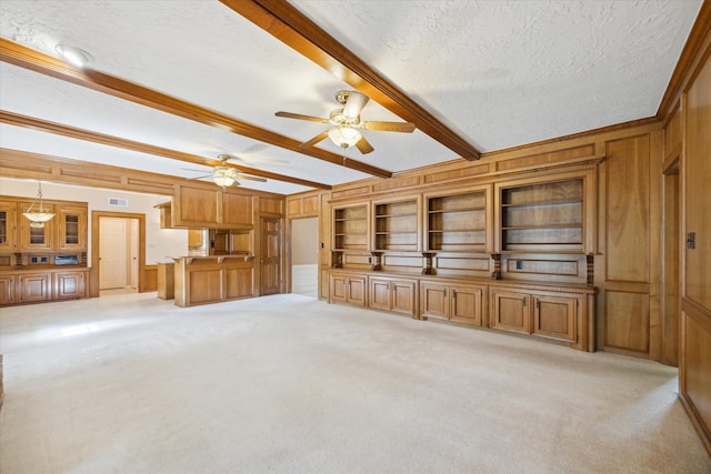 unfurnished living room with light carpet, beamed ceiling, and a textured ceiling