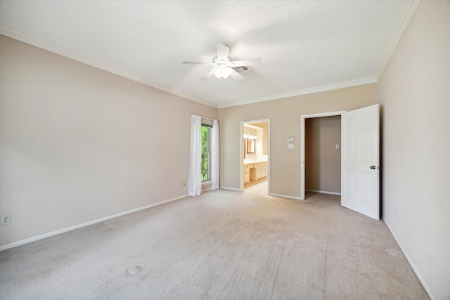 empty room featuring crown molding, ceiling fan, and light carpet