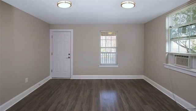 spare room featuring cooling unit and dark wood-type flooring