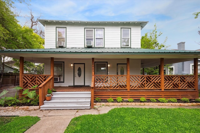 farmhouse-style home with a front lawn, cooling unit, and a porch