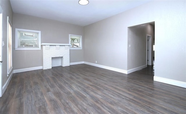 unfurnished living room featuring a fireplace and dark wood-type flooring