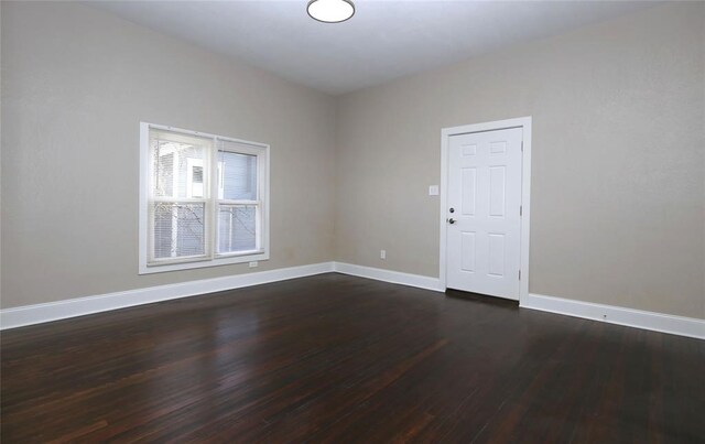 empty room with dark hardwood / wood-style flooring