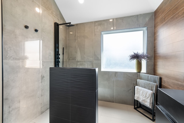 bathroom featuring tile patterned flooring, tile walls, lofted ceiling, and tiled shower