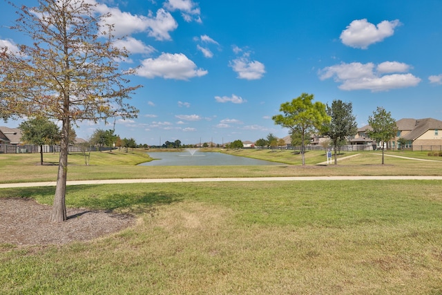 view of home's community with a lawn and a water view