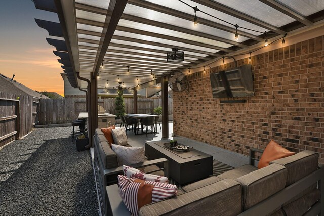 patio terrace at dusk with an outdoor living space with a fire pit and a pergola